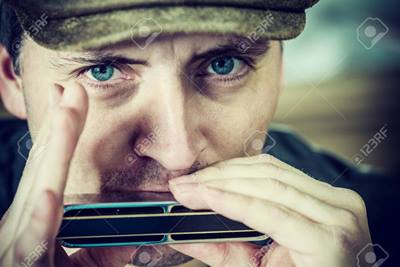 close up portrait of a man playing a harmonica