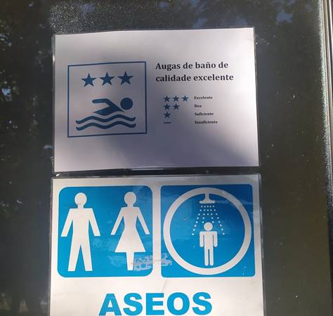 Cartaz informando da excelencia das augas de baño nos aseos, en Porto Quintela